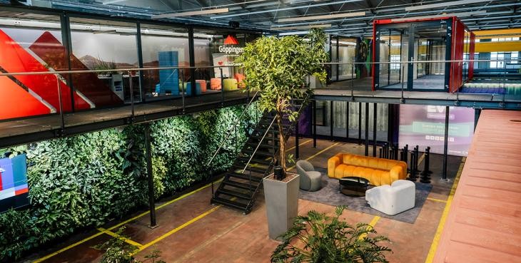 Innenaufnahme aus dem Hive, mehrere Container sind übereinander gestapelt, davor stehen Möbel