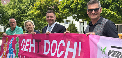 Vier Personen halten ein Banner mit der Aufrischt "Geht doch"