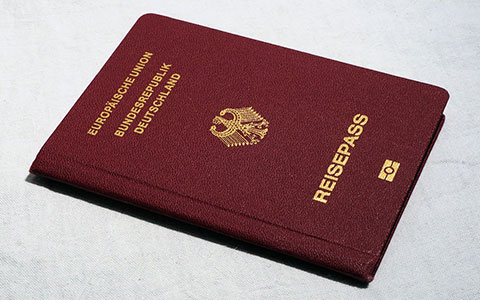 Ein deutscher Reisepass steht auf einer Karte